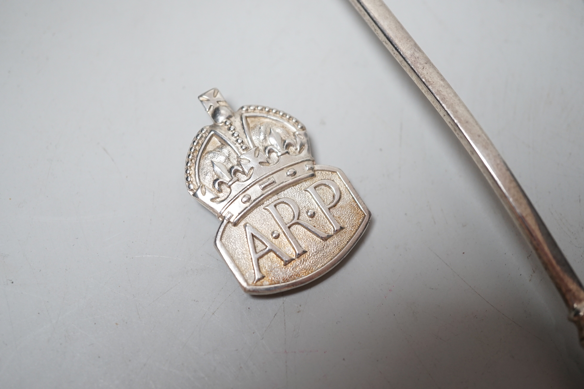 A pair of Edwardian silver apostle spoons, London, 1906 and an ARP badge